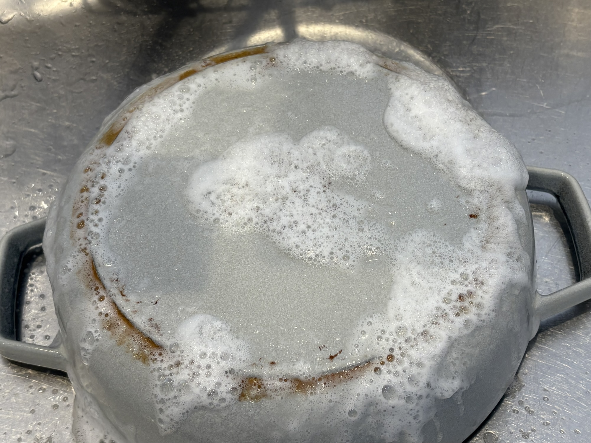 ストウブ外側の汚れ落とし アズマジックコゲ取り洗剤を吹きかけた様子